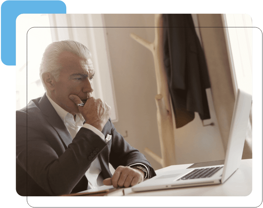 A man sitting at his desk looking at the computer screen.