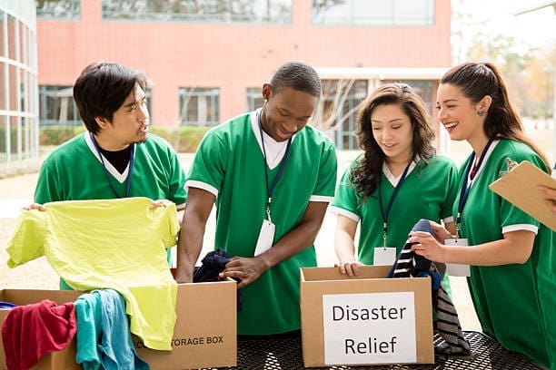 Organized group of multi-ethnic college student volunteers collect clothing donations for recent disaster relief efforts.