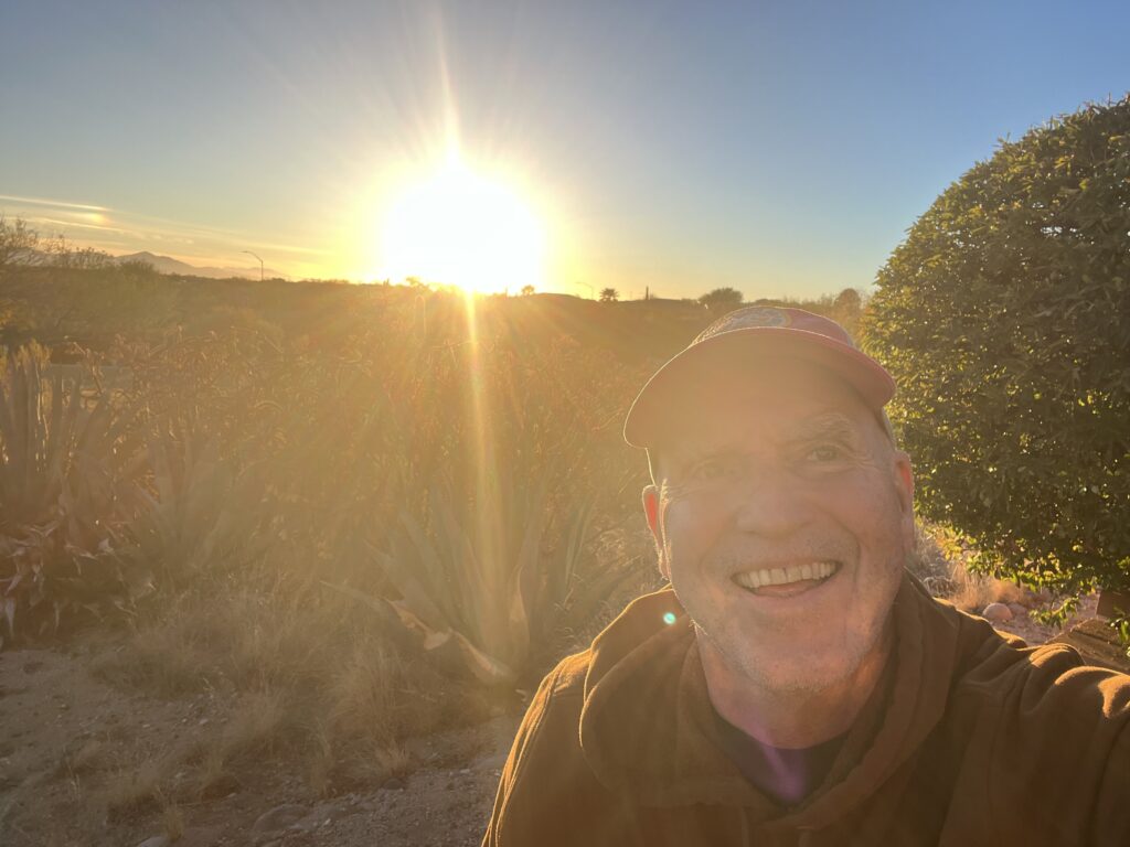 Smiling man with sunset in background.