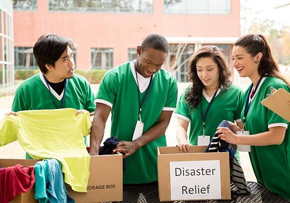 Organized group of multi-ethnic college student volunteers collect clothing donations for recent disaster relief efforts.